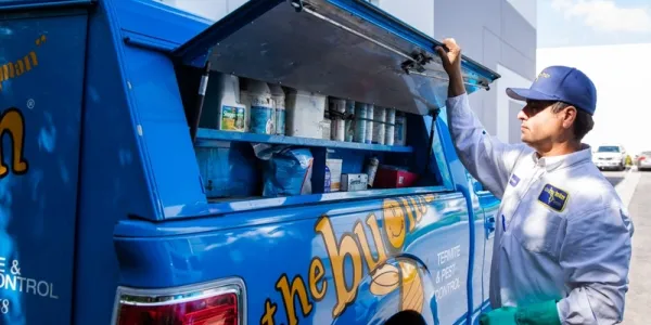 the bugman exterminator standing by the truck